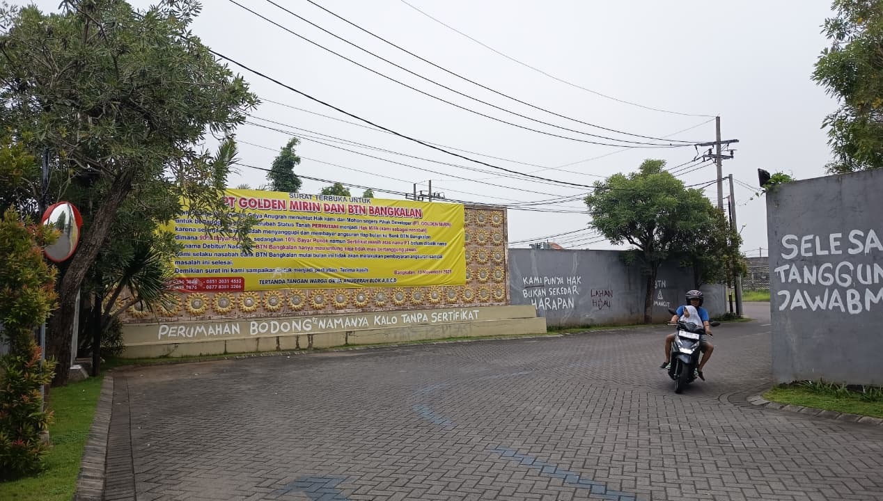 BERMASALAH: Pengendara melintas di pintu masuk Griya Anugerah, Kelurahan Mlajah, Bangkalan, Senin (17/11).&nbsp;