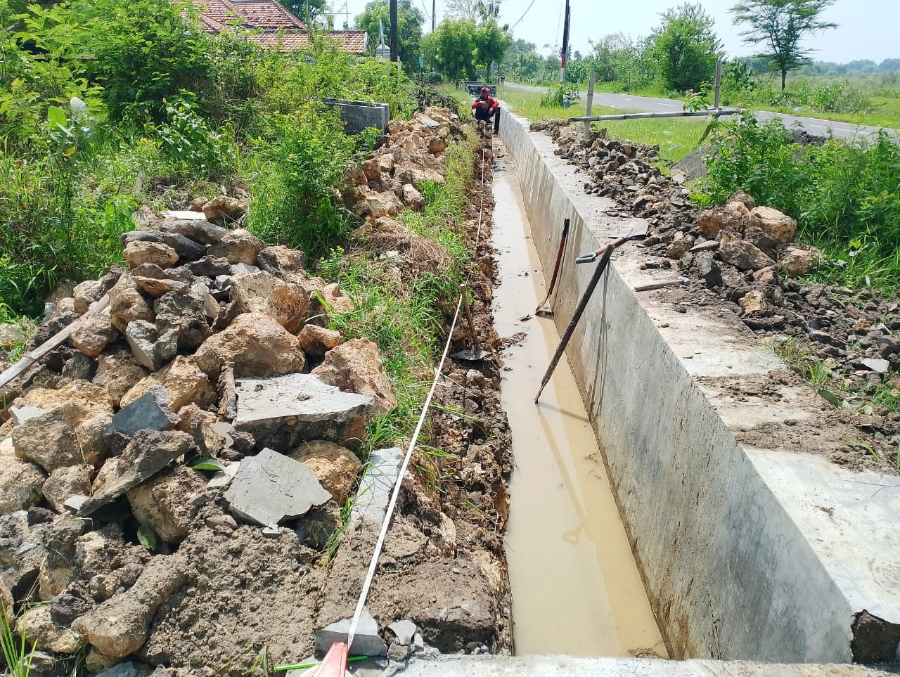 SEUMUR JAGUNG: Pekerja mengkur kerusakan proyek pembangunan saluran di Desa Apaan, Kecamatan Pangarengan yang ambruk, Selasa (21/11).