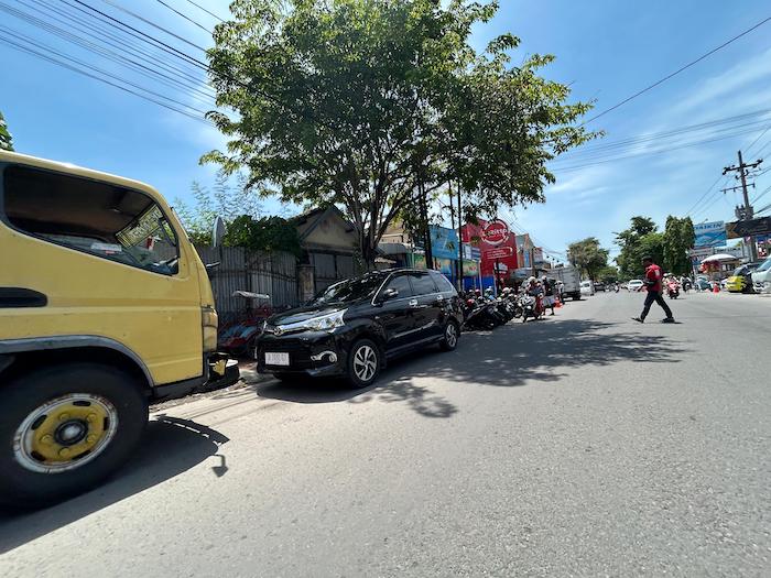 RAWAN BOCOR: Jukir mengawal pengendara di Jalan Panglima Sudirman Bangkalan, Selasa (21/11).&nbsp;
