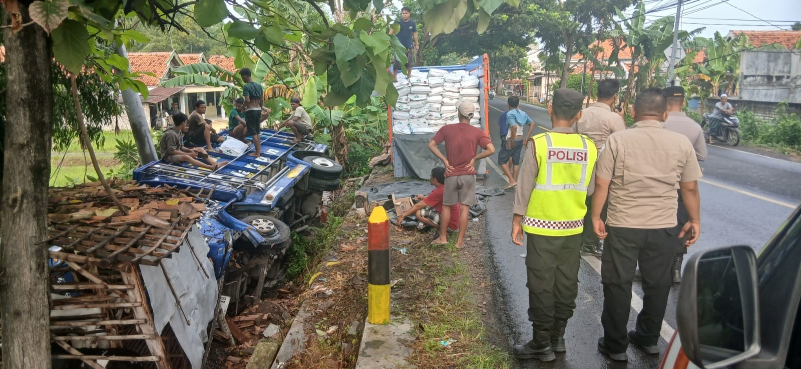 TERGULING: Anggota Polres Sampang berada di lokasi lakalantas yang terjadi di Jalan Raya Bancelok, Kecamatan Jrengik, Sampang, Rabu (26/11).