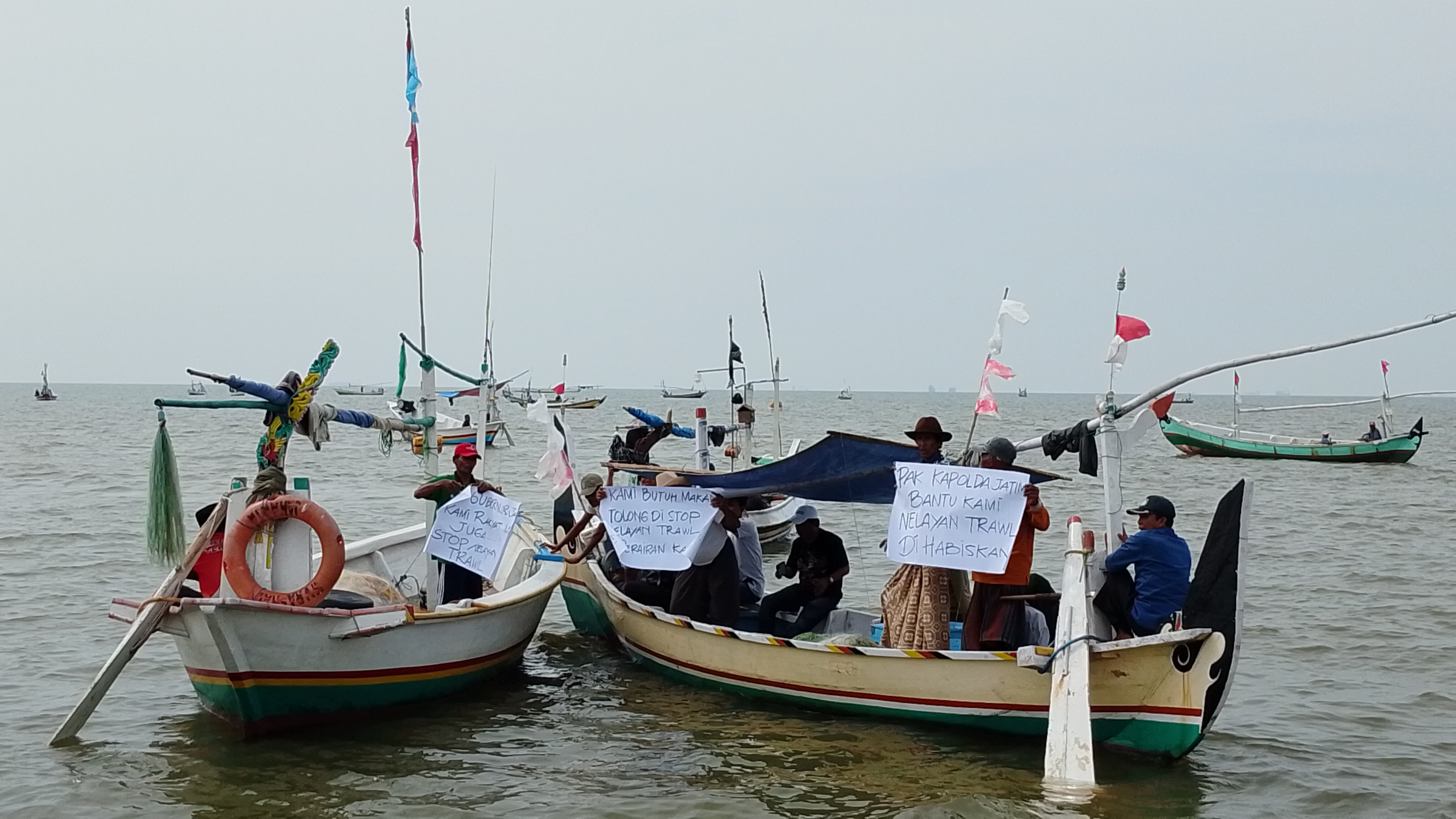 Nelayan di Arosbaya Bangkalan membentangkan poster yang bertuliskan bentuk protes terhadap nelayan luar daerah yang menangkap ikan menggunakan jaring trawl di perairan Desa Tengket, Kamis (27/11/2025.