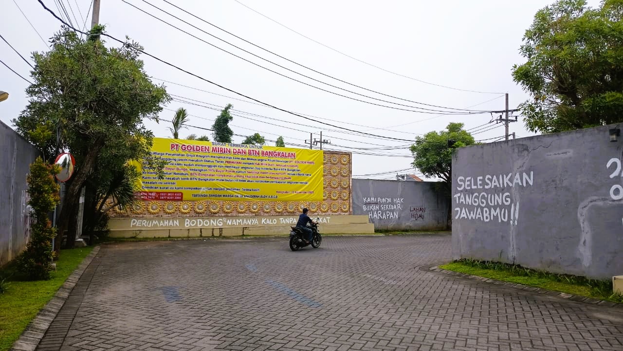 BERMASALAH: Pengendara melintas di pintu masuk Perumahan Griya Anugerah pada Senin (17/11).&nbsp;