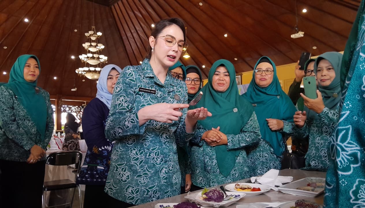 DEKAT: Ketua TP PKK Jatim, Arumi Bachsin, mencoba hasil olahan PMT lokal Pamekasan, di Pendopo Ronggosukowati, Jumat (28/11).&nbsp;
