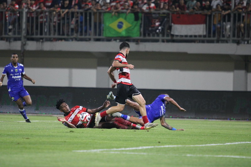 &nbsp;  MELAWAN: Bek Madura United Mendonca tenggah mencoba menghalau pemain Persib di Stadion Gelora Ratu Pamelingan Pamekasan, Minggu (30/11).&nbsp;