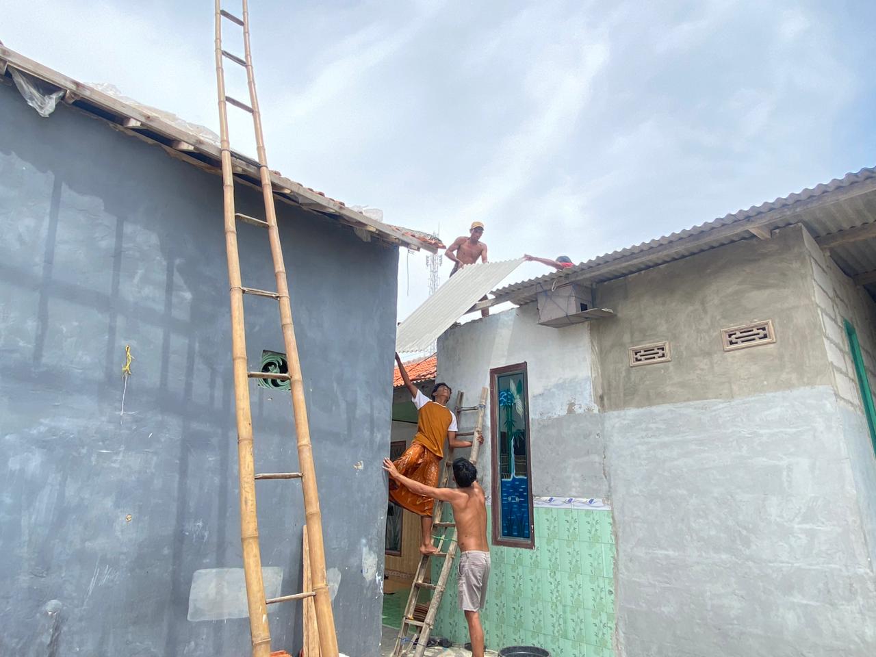 PERISTIWA: Warga saat memperbaiki atap rumahnya yang rusak akibat diterjang puting beliung di Desa Dharma Camplong, Kecamatan Camplong, Sampang,&nbsp;Selasa (16/12).