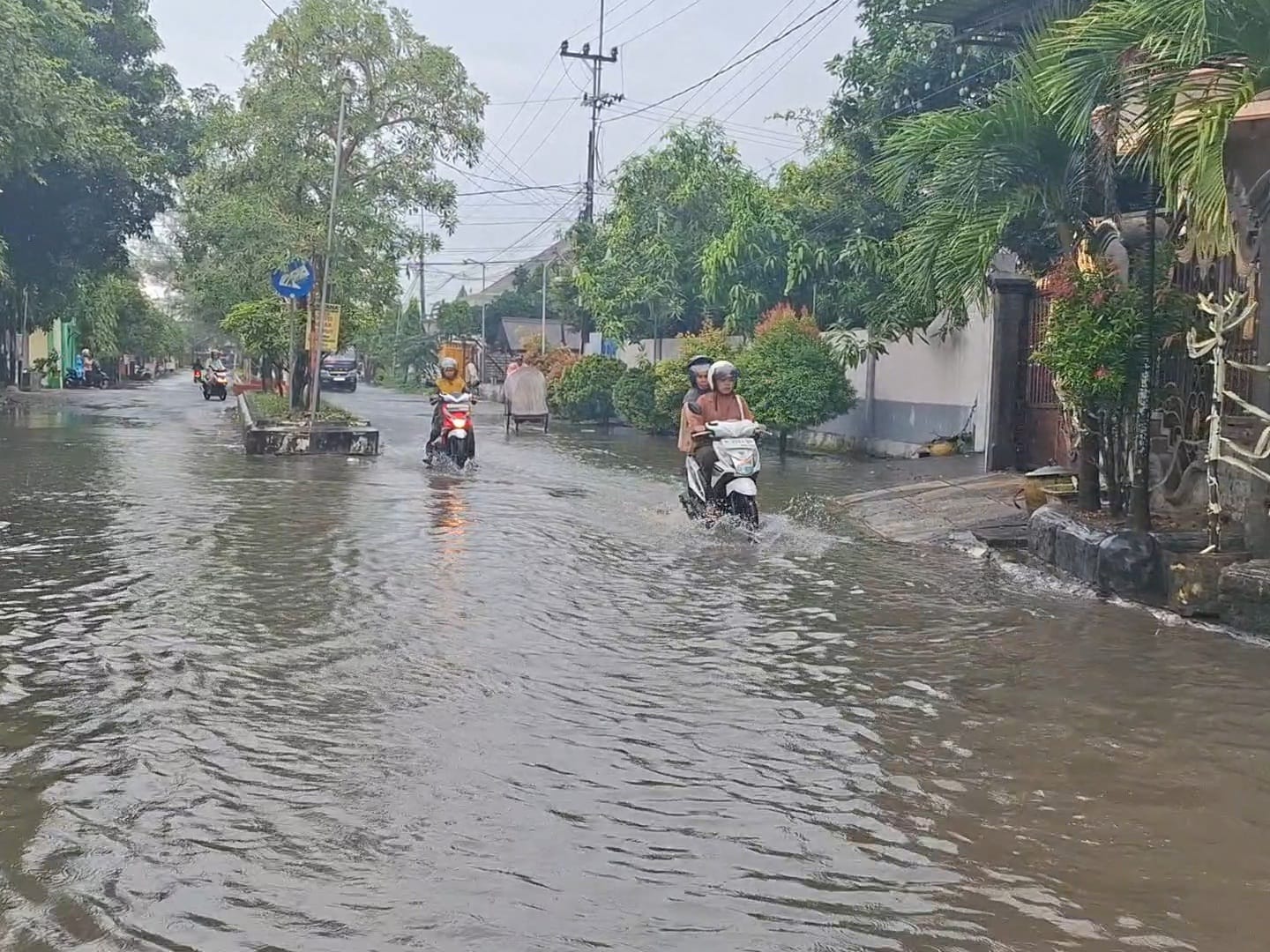 MELUAP: Sejumlah pengendara tetap melaju di genangan air di Jalan Sultan Abdurrahman, Desa Kolor, Kecamatan Kota Sumenep, Kamis (20/11).&nbsp;
