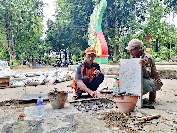 BELUM TUNTAS: Tukang memasang keramik di Taman Bunga Pottre Koneng Sumenep,&nbsp;Jumat (19/12).&nbsp;