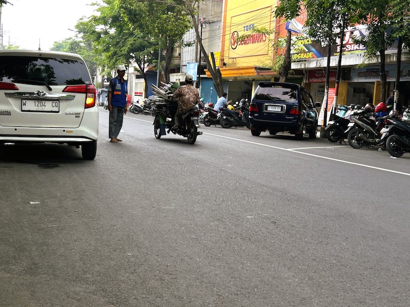 HARUS DIEVALUASI: Juru parkir di Jalan Panglima Sudirman, Bangkalan, tengah mengawal kendaraan, Senin (22/12).&nbsp;