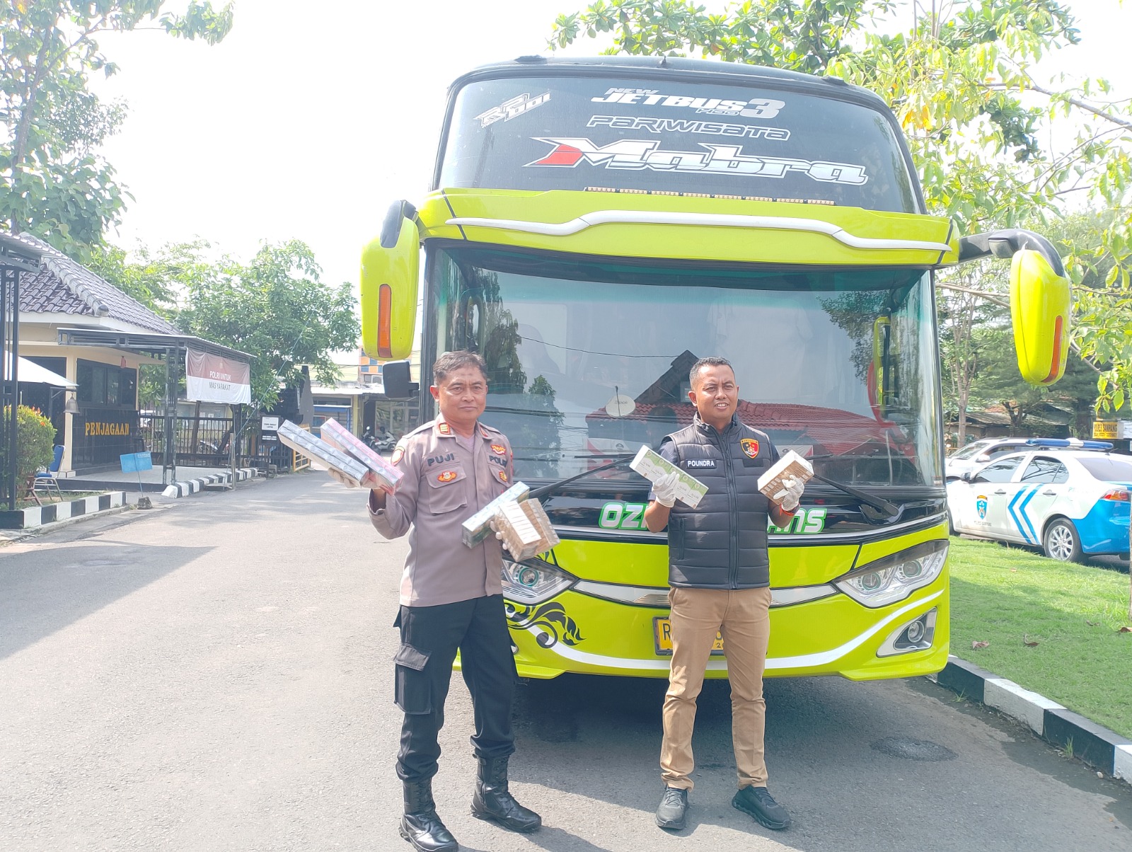 ILEGAL: Plh Kasihumas Polres Sampang AKP Eko Puji Waluyo dan KBO Satreskrim Ipda Paundra Kinan Aditama menunjukkan BB yang diamankan dari bus di halaman Mapolres Sampang saat konferensi pers.