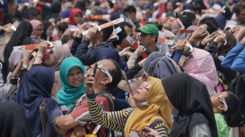 Pengunjung menggunakan kacamata khusus melihat proses gerhana matahari cincin di Planetarium Taman Ismail Marzuki, Jakarta, Kamis (26/12).  Foto: Helmi Afandi Abdullah/kumparan