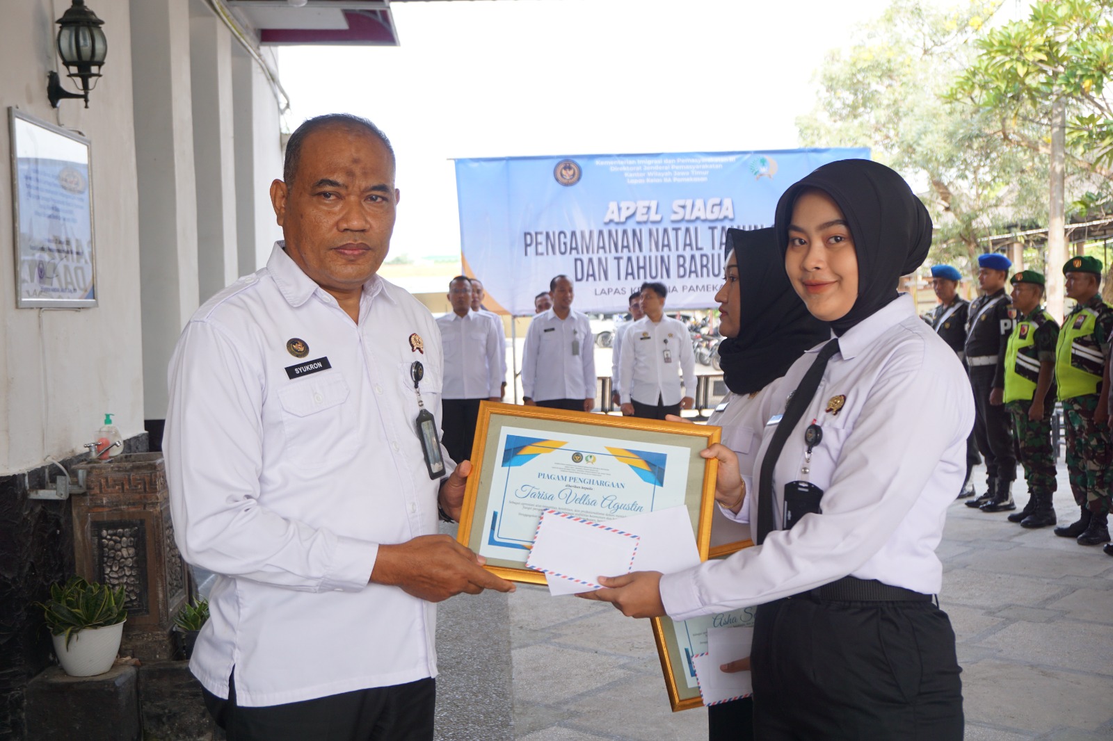 APRESIASI: Kepala Lapas Kelas II-A Pamekasan Syukron Hamdani memberikan penghargaan kepada petugas sipir perempuan Tarisa Vellsa Agustin saat apel, Rabu (24/12).&nbsp;&nbsp;