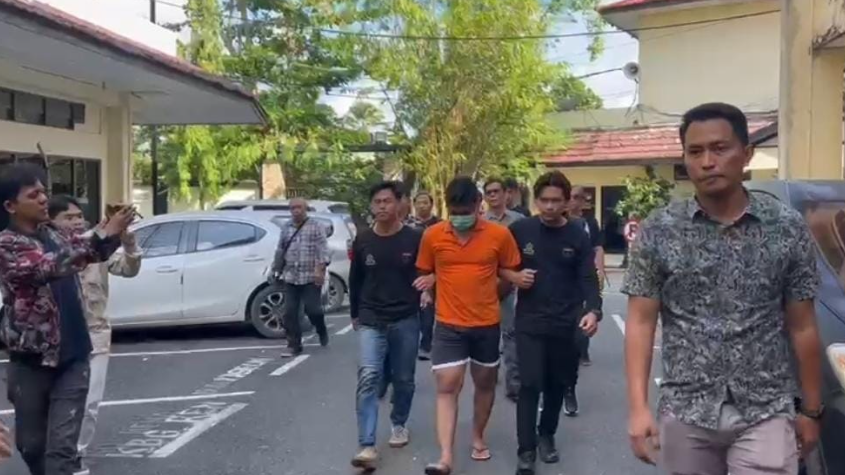 Pelaku (tengah) digiring petugas. (Foto : Api)