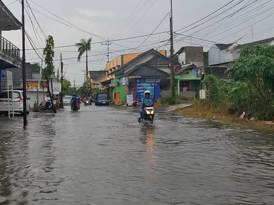 TERGENANG: Sejumlah pengendara menerobos genangan air di Jalan Sultan Abdurrahman, Desa Kolor, Kecamatan Kota Sumenep, Kamis (20/11).&nbsp;