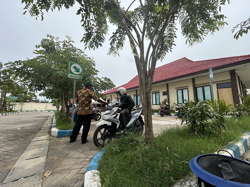 DIKELOLA PROVINSI: Petugas parkir berada di halaman kantor Samsat Bangkalan, Rabu (7/1).&nbsp;