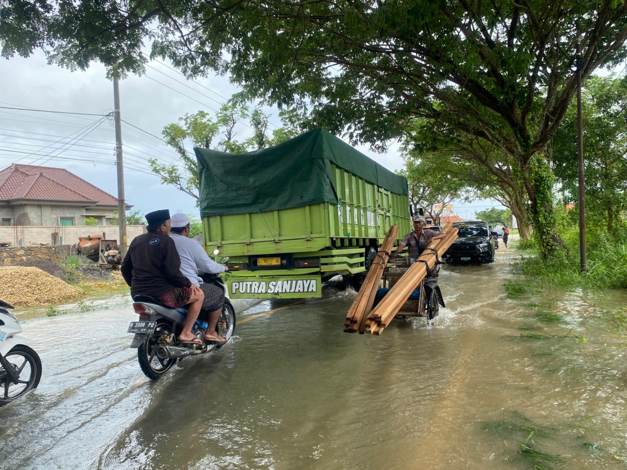 TERGENANG: Pengendara melintasi genangan air di Jalan Raya Tanjungbumi, Senin (12/1).&nbsp;