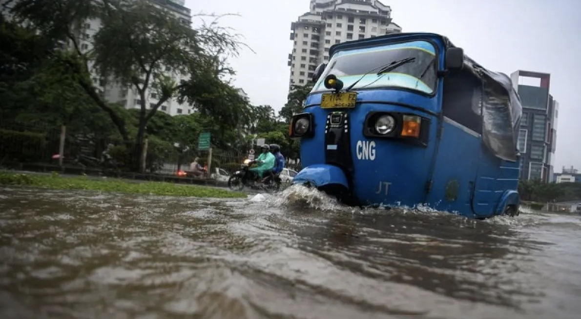 Pengendara bajaj melintasi banjir di Kemayoran, Jakarta, Senin (12/1/2026). BPBD DKI mencatat 23 ruas jalan dan 10 RT di Jaksel dan Jakut terendam akibat hujan deras dan drainase buruk. Foto: ANTARA