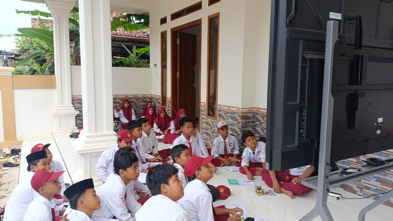 TAK REPRESENTATIF: Puluhan siswa SDN Tlagah 2 Bangkalan mengikuti KBM di teras rumah warga Selasa (13/1).&nbsp;