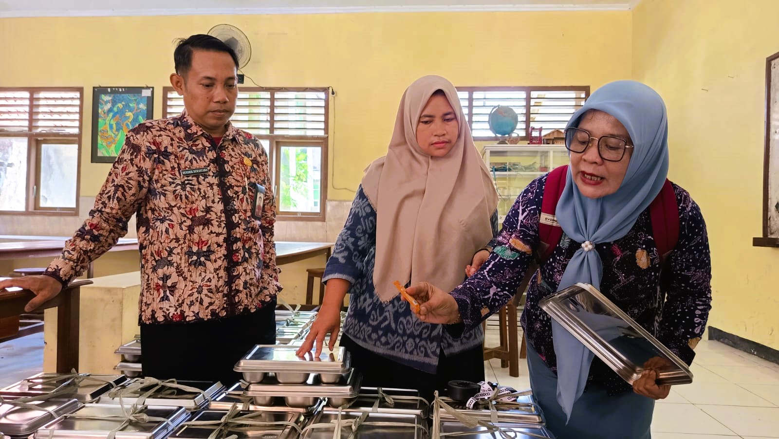 TELITI: Guru SMAN 3 Bangkalan mengecek menu MBG sebelum dibagikan kepada anak didik pada Kamis (18/9/2025).