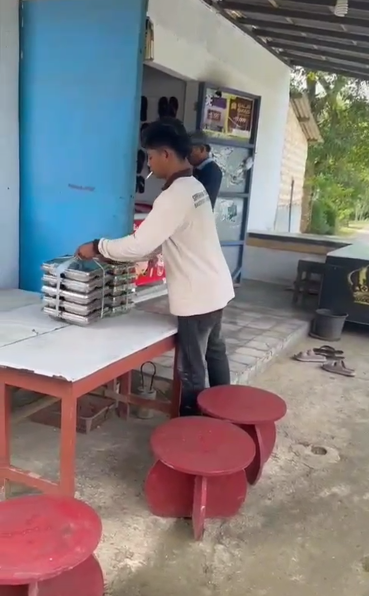 JANGGAL: Petugas SPPG menurunkan MBG dan diletakkan di rumah warga di Desa Batuporo Timur, Kecamatan Kedungdung, Sampang, Selasa (20/1).&nbsp;