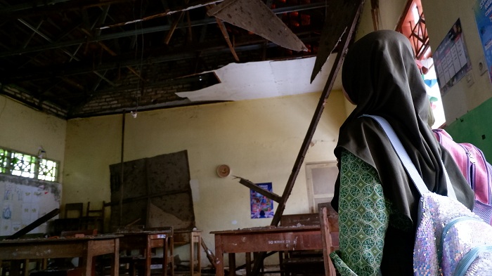 RUSAK: Siswa SDN Kramat 1 Bangkalan berada di depan ruang kelasnya, Rabu (28/1).