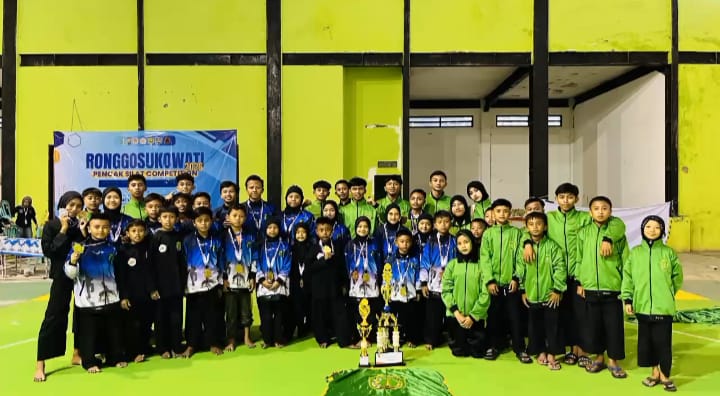 PENUH SEMANGAT: Pesilat perguruan Pamur Sampang berpose bersama usai menerima penghargaan kejuaraan Ronggosukowati Pencak Silat Competition 2026 di GOR Sahabat Pamekasan, Minggu (1/2).&nbsp;