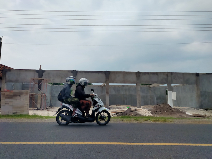 BELUM RAMPUNG: Pengendara sepeda motor melintas di depan proyek pembangunan gerai KMP di Desa Keleyan, Kecamatan Socah, Rabu (11/2).&nbsp;