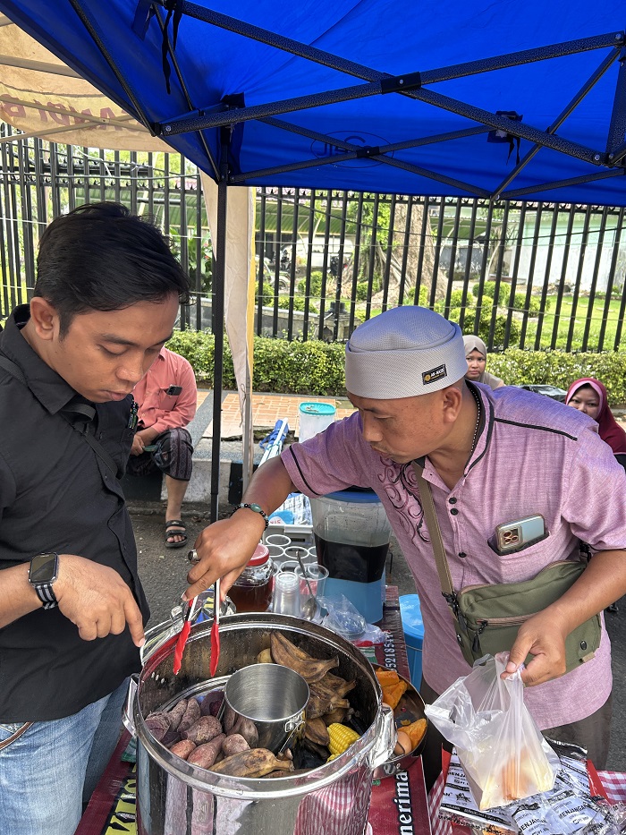 SEHAT: Saniman tengah melayani pembeli saat berjualan di Bazar Takjil Ramadan di Alun-Alun Bangkalan.