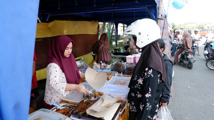 NIKMAT: Pedagang lauk di stan 15-16 saat melayani pembeli di Bazar Takjil Ramadan Jumat (20/2). VIVIN AGUSTIN HARTONO/JPRM