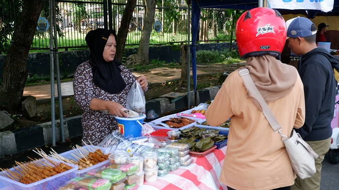 VARIATIF: Penjual saat menyiapkan pilihan lauk yang dipesan oleh pembeli di stan Bazar Takjil Ramadan.
