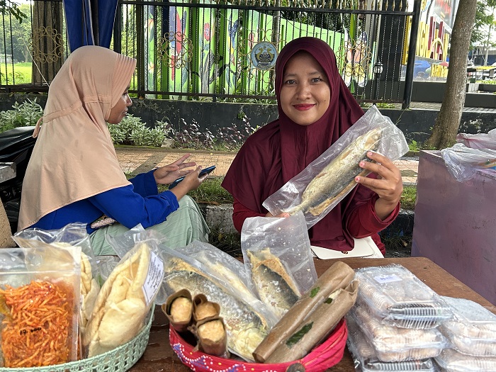 OLAHAN: Nur Adhima menunjukkan otak-otak bandeng menu favorit di stan 4 Bazar Takjil Ramadan, Bangkalan.