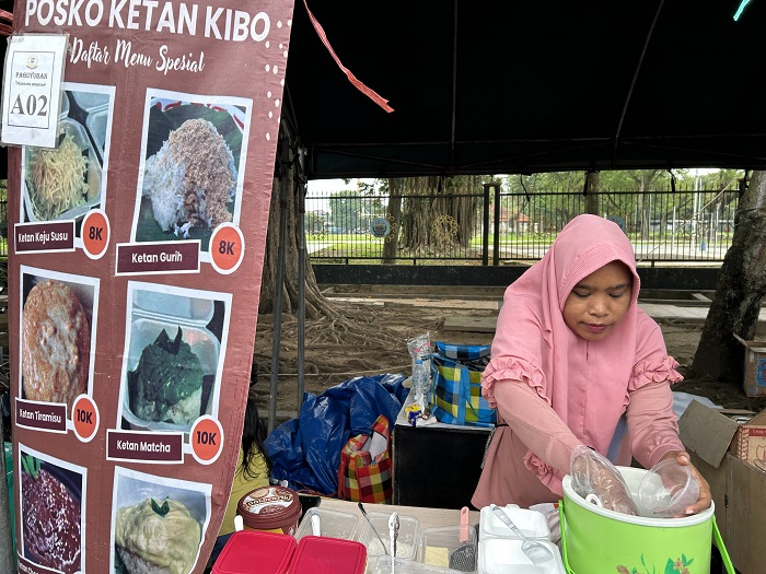 JAJAN TRADISIONAL: Nia, karyawan Posko Ketan Kibo, sedang menyiapkan pesanan di stan 96 Bazar Takjil Ramadan, Bangkalan, Minggu (1/3). 