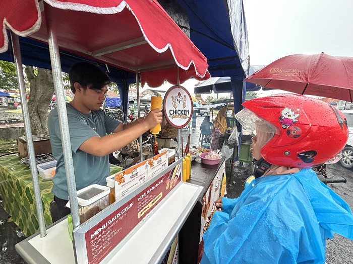 KEKINIAN: Asrofil Anam melayani pembeli Chiken Chruncy Roll di stan 2 Bazar Takjil Ramadan, Bangkalan, Selasa (3/3).