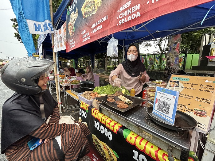 BIKIN NGILER: Santi, pemilik Kebab Lumbeef, melayani pembeli di stan Bazar Takjil Ramadan, Bangkalan, Selasa (3/3).