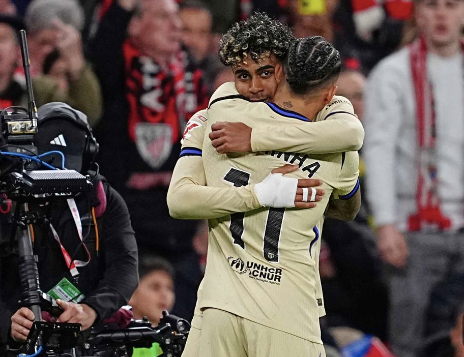 Lamine Yamal (depan) dipeluk Raphinha usai mencetak gol saat Barcelona menang 1-0 atas Athletic Bilbao di San Mames, 7 Maret 2026. (AP Photo/Miguel Oses)