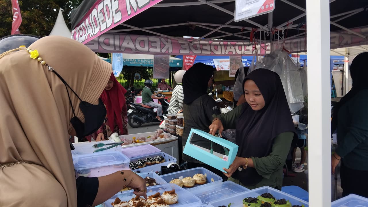 Penjaga stan Kedai Dede melayani pembeli di area Bazar Takjil Ramadan Bangkalan. Athoya Hanin