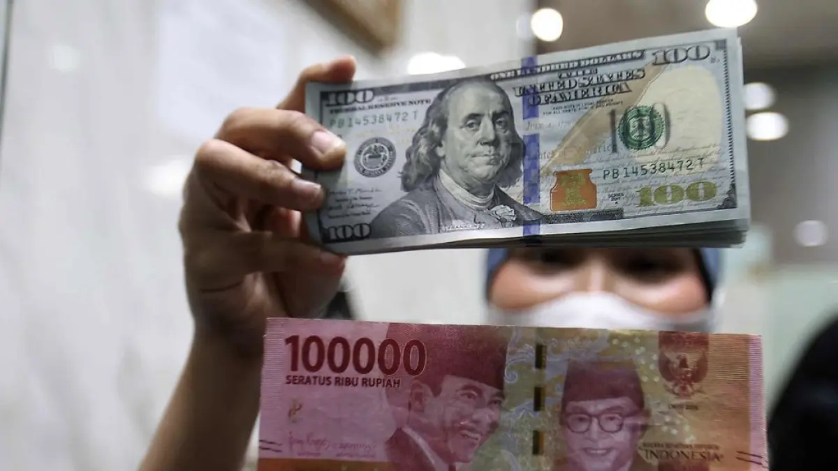 Karyawan menunjukkan uang pecahan dolar Amerika Serikat (AS) dan rupiah di salah satu gerai penukaran mata
uang asing, Jakarta, Rabu (5/5/2026). (Kapanlagi.com/Budy Santoso)
