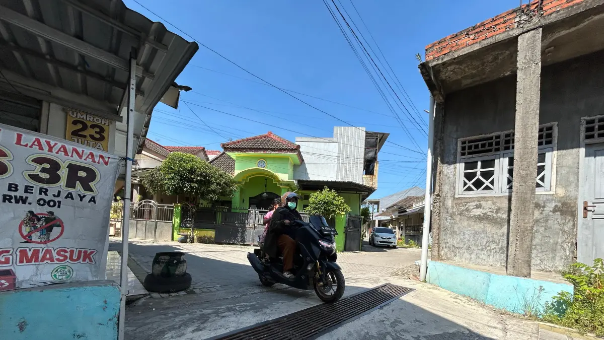 LENGANG: Pengendara sepeda motor melintas di depan gerbang Perumahan Graha Candra Land Bangkalan Senin (1/6). (VIVIN AGUSTIN HARTONO/JPRM)