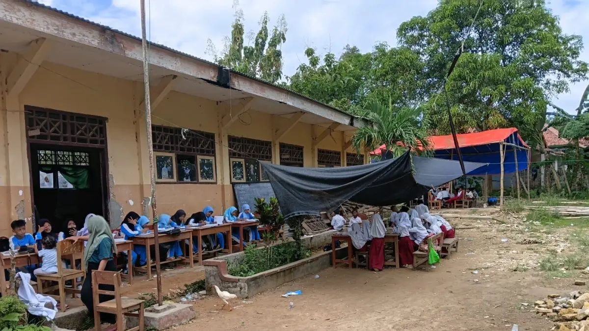 RUSAK BERAT: Puluhan siswa SDN Kajuanak 4, Galis, Bangkalan, melaksanakan kegiatan pembelajaran di bawah tenda, Selasa (28/4). (SDN KAJUANAK 4 UNTUK JPRM)