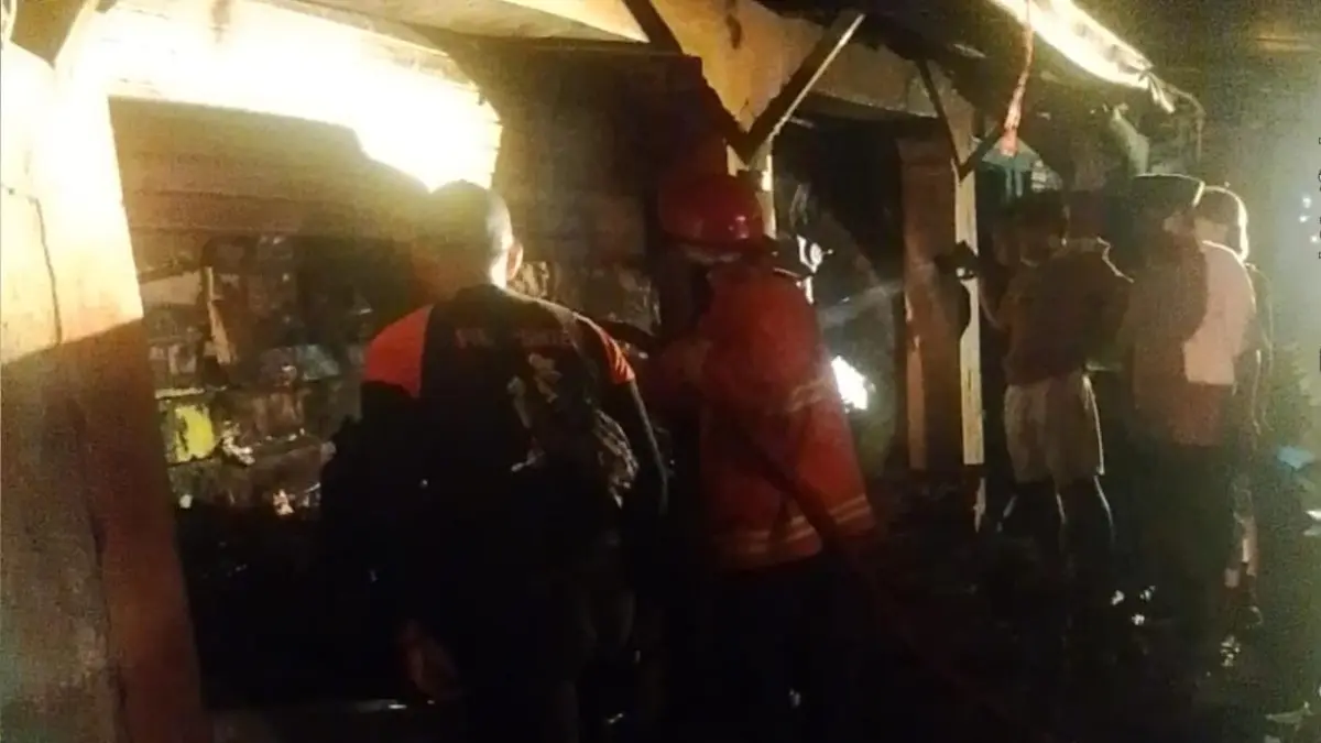 MEMBARA: Petugas pemadam kebakaran Satpol PP Bangkalan berusaha memadamkan kobaran api di Pasar Baru Kedungdung, Desa Patereman, Kecamatan Modung, Bangkalan, Senin (8/6). (DAMKAR BANGKALAN UNTUK JPRM)