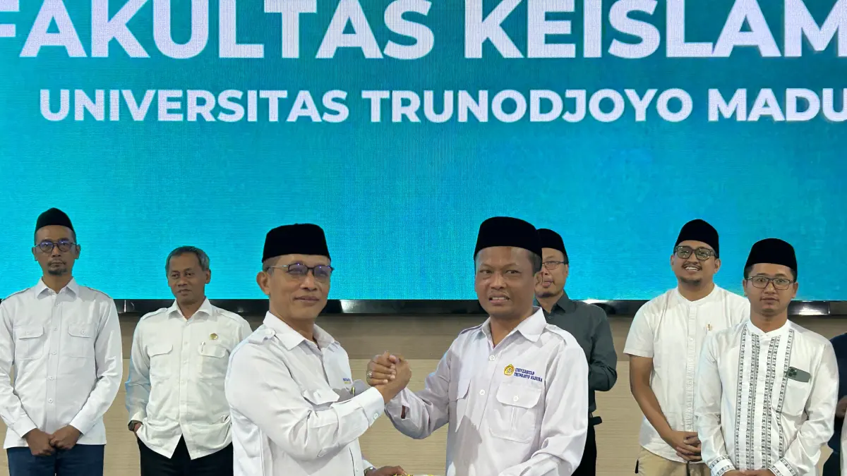 SELAMAT: Rektor UTM Prof. Safi’ (kanan) menyerahkan potongan tumpeng kepada Dekan FKis UTM Abdur Rohman di gedung pertemuan Senin (8/6). (VIVIN AGUSTIN HARTONO/JPRM)