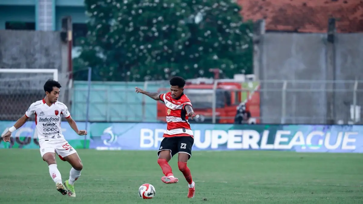 MEMBANGUN SERANGAN: Pemain Madura United, Gio Numberi, berupaya melewati hadangan pemain Bali United dalam laga di Stadion Gelora Bangkalan, Selasa (5/5). (MADURA UNITED)