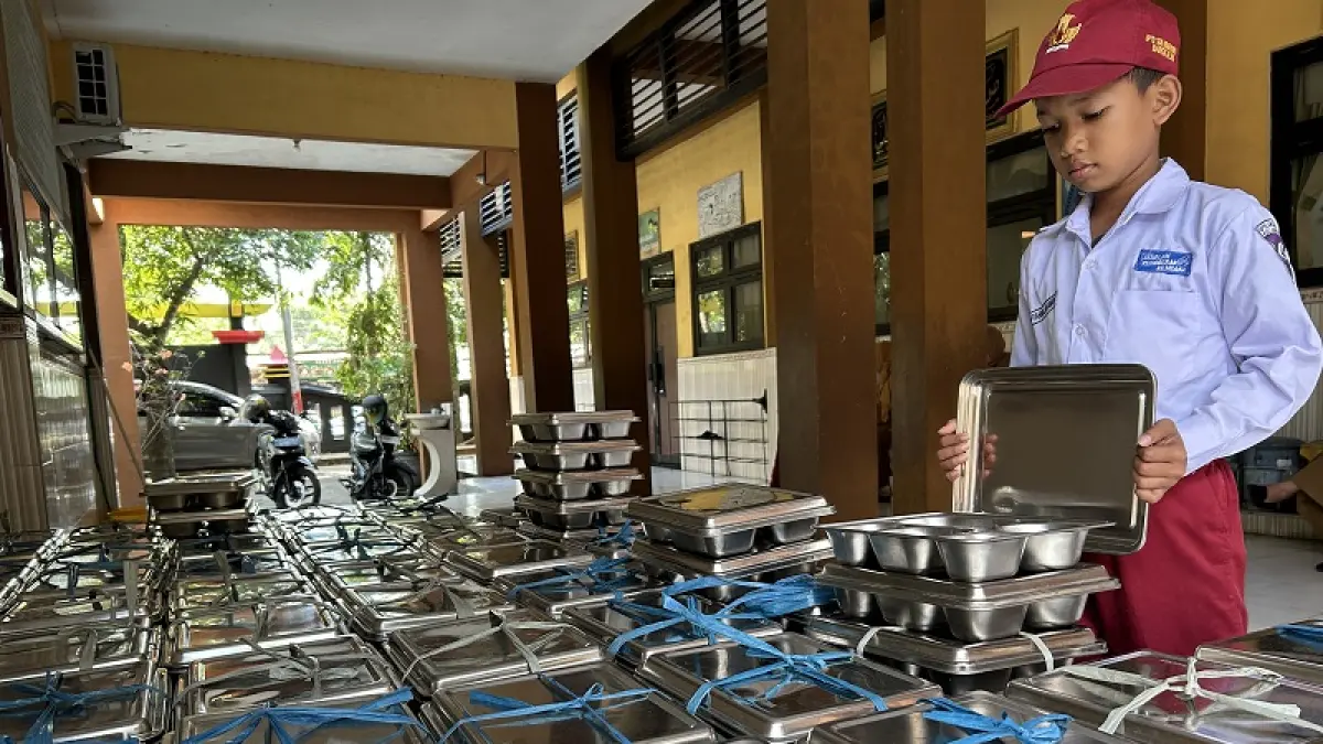 AMAN: Siswa SDN Kemayoran 1 Bangkalan mengecek makan bergizi gratis (MBG) sebelum dikonsumsi Senin (13/7). (VIVIN AGUSTIN HARTONO/JPRM)