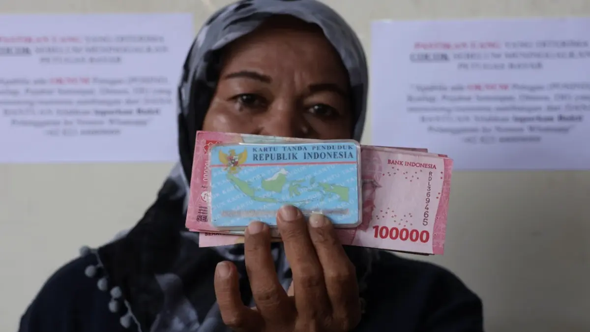 Warga memperlihatkan uang tunai bantuan sosial Program Keluarga Harapan (bansos PKH) yang diterimanya di
Kantor Pos Indonesia Makassar, Sulawesi Selatan( ANTARA FOTO/Arnas Padda/tom.)