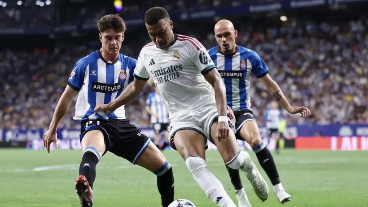 Roger Hinojo (kiri) membayangi Kylian Mbappe (tengah) dalam pertandingan sepak bola Liga Spanyol RCD Espanyol vs Real Madrid CF
di Stadion RCDE di Cornella de Llobregat pada 22 Agustus 2026. (Foto oleh Josep LAGO / AFP) (AFP/JOSEP LAGO)