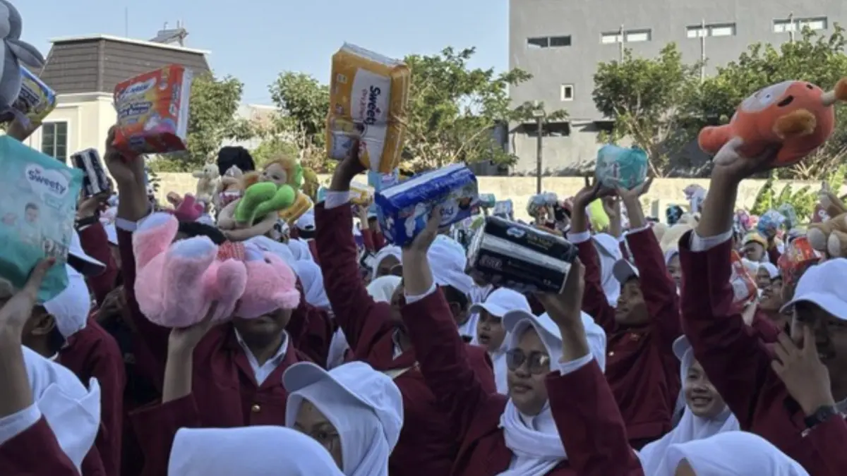Aksi ribuan maba Umsura mengangkat boneka, pembalut dan boneka bentuk kepedulian korban bencana anak dan perempuan NTT. (Foto: Esti Widiyana/detikJatim)