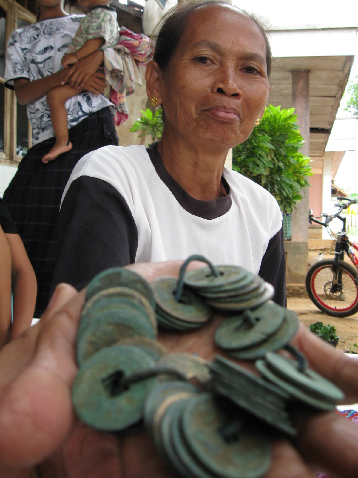 Rasimah menunjukkan sebagian dari setengah karung uang China yang ditemukan di jalan Desa Rawasan, Kecamatan Jenu pada 28 Desember 2008.