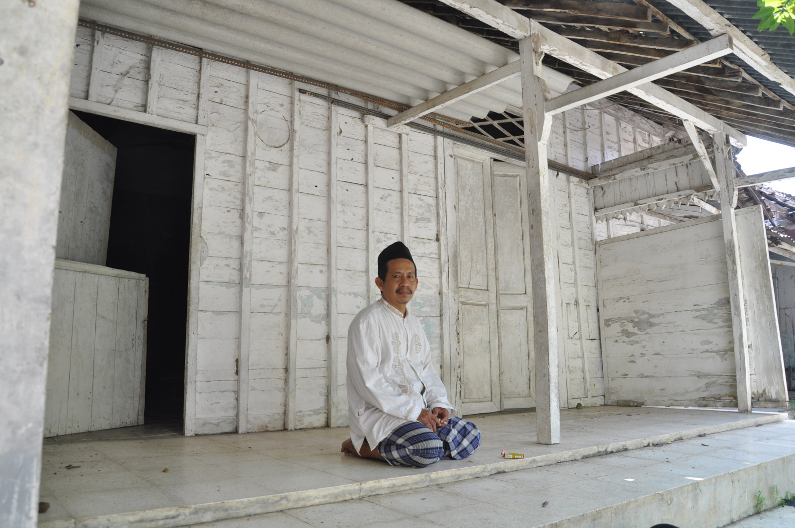 Gus Mujabul Marom duduk di teras surau, bangunan kuno di Ponpes Ash-Shomadiyah Tuban.