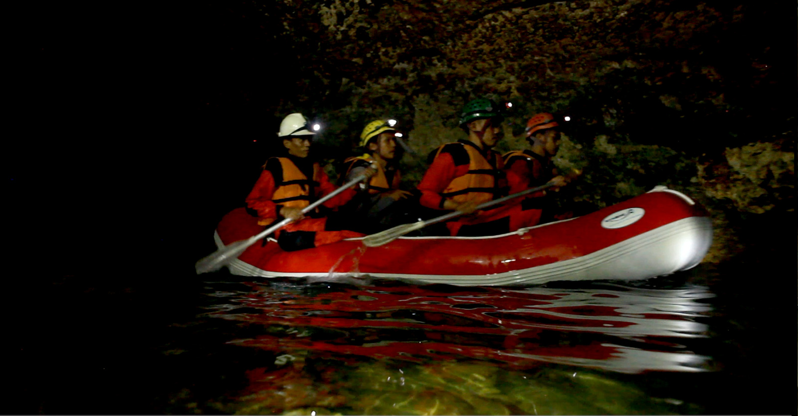 Pecinta alam menyusuri sungai di dalam Gua Ngerong dengan perahu karet.