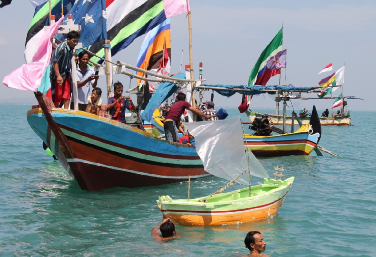 Nelayan Kelurahan Karangsari, Kecamatan Tuban, Kabupaten Tuban, Jawa Timur membawa miniatur kapal berisi sesaji menuju kapal yang mengangkut ke tengah laut.