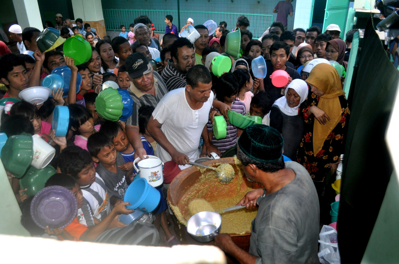 Warga mengantre bubur suro di halaman Masjid Muhdlor Tuban di Jalan Pemuda, Tuban, Jawa Timur.